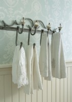 Always careful to display items in their best light, Kathy hangs French towels from a wrought iron hooks with crystal finials.