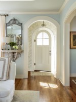 A  small foyer opens into the living room through the original arch doorway that highlights the style of the front door.
