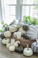 Electric candles are placed among the display  to keep the gourd centerpiece safe while adding a soft glow in the evening.