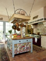 A space saving pot rack stands above the stout island that was painted in duck egg blue, wb=chin matches the doors' trim. 