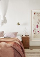 Large fabric artwork in frame next to bed