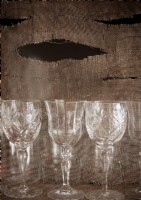 Detail of wine glasses on shelf backed by hessian sack