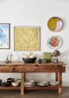 Display of artwork and accessories on wooden dining room sideboard