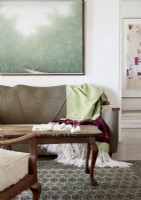 Green painting on wall above brown sofa