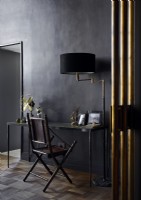Classic desk and chair with black painted walls and gold accessories