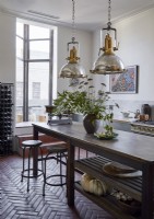 Large salvaged lamps hanging over wooden kitchen island