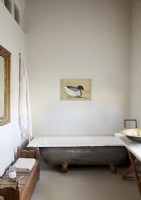 Painting of a duck over old tin bath in country bathroom