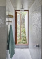 Wet room with shower running and open window to garden