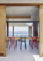 Colourful chairs in contemporary dining room with coastal views 