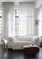 White sofa and soft furnishings on sofa in front of window