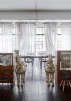 Two horse sculptures flagging cabinets in dining room
