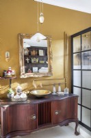 Bathroom with vintage cabinet vanity and gold walls