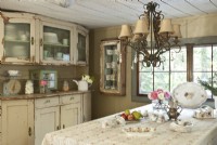 The dining room centers around a family-size farm table. A weathered sideboard and cupboards provide storage for Michelle's mix of restaurant dishes and sturdy earthenware. 