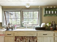 A floral skirt hides necessary items and softens the cupboardsâ€™ aged finish. 