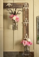 An old frame outfitted with hooks offers an unusual display spot for flower-filled jars.
