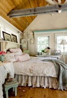 A soft blend of pastel hues adds romantic undertones to the new bedroom addition. The bare floor exposes the raw beauty of the wood   and provides a link to the original cabin.