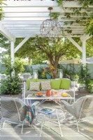 A newly constructed arbor provides both structure and shade to the homeâ€™s patio. Woven metal Russell Woodard outdoor wear a powder coating in pale gray. The cool chandelier was a Mexican wire ball sculpture that Ryan had wired.