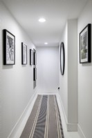 Modern white walled hallway with artwork.