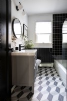 Modern bathroom with black and white tiles.