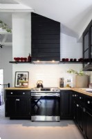 Modern kitchen details with black cupboards.
