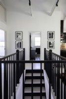 Stairway in hall painted black and white with black and white photography.