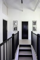 Stairway in hall painted black and white with black and white photography.