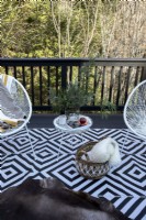 Details of outdoor seating on wooden deck in countryside.