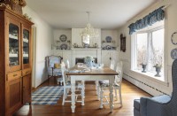 A Victorian fireplace mantle, a spacious table, a stately sideboard, and a blue and white theme sets the dining room French farmhouse comfort.