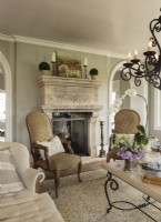  Lorna had the walls designed around this antique French fireplace; they are extra thick to house the two-way limestone beauty. Sheâ€™s owned the carved chairs for more than 20 years. â€œ