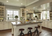 The kitchen islandâ€™s counterop is fashioned from pewter, inspired by a restaurant in France. The tongue-and-groove ceiling is original to the home.