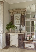 Lorna reimagined several pieces of salvage to create this clever wet  bar. The white center pieceâ€”a section saved from an old cupboardâ€”is surrounded by drawers made of vintage wood. The same wood was used to make wall shelves that drop from a salvaged eyebrow window frame.