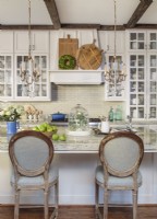 Matching crystal chandeliers, Louis XVI style chairs, ironstone ceramics both old and new, set the tone for the kitchen.