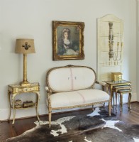 A Texas cowhide anchors an elegant seating area in the master bedroom.