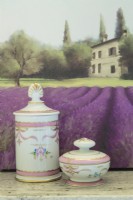 A small painting of a chateau and lavender fields backs a delicate Limoges bath set. 