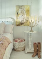 Set on a salvaged table, a vintage candelabra romances the simple bedroom.