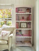 The rusticity of the  bookcase is soften with a coat of pale pink and a dainty scalloped trim.