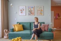 A smiling woman sitting on a green sofa