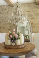 Candles and roses make a romantic centerpiece that highlights the rustic elegance of the room.