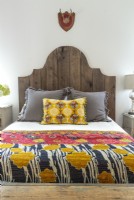 Darryl made the headboard and Annie made the bedspread and pillows; other pieces add deep primary hues to the mix. 