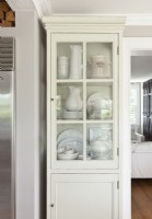 A tall, slender cupboard offers an elegant storage solutions for delicate serving wares.
