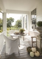 Overlooking rolling hills and pastures, the farmhouse front porch is a favorite place for the family to gather.