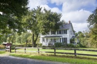 A venerable oak tree and open fields conspire to give the 1800s farmhouse a picture-perfect setting.
