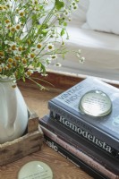 Favorite books and objects are gathered into a vintage wooden tray on a farmhouse table trimmed to coffee-table height.