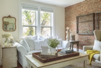 A section of brick framed by a walnut-drying rack, and a white couch that seems to recede into the light are among the skillful ways Melisa suggests space. 