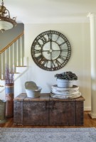 A circa-1500s trunk with original hardware offers stylish storage. The iron clock is a foyer focal point that echoes a circular theme, which includes the architectural corbel below. 