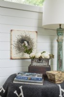 Agree and white horse blanket covers a small table. The aqua wood lamp is one of several painted pieces.