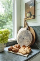 A collection of farmhouse wood breadboards awaits a call to duty on the honed soapstone kitchen counter.