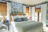 Soft shade a blue  animate a guest bedroom. For counterpoint a seagrass headboard, a raffia bolster and bamboo shades add texture.
