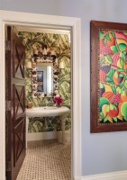 Nature comes in via the powder room banana-leaf wallpaper pattern and a colorful painting.
