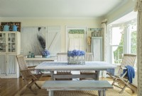 Weathered teak  garden chairs and a bench provide seating for a trestle table in the kitchen area.